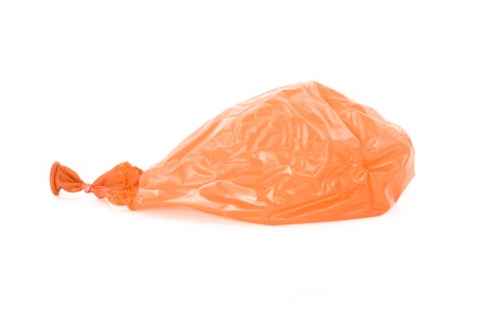 Deflated orange balloon isolated over white backgroundの写真素材