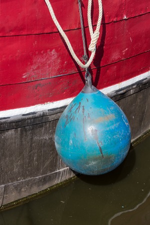 Blue fender of an old fishing boatの写真素材