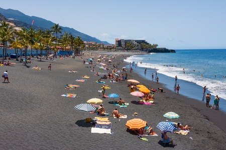 LA PALMA, SPAIN - JULY 20: Sunbathing people at beach with black lava sand on July 20, 2008 near Puerto Naos at La Palma Island, Spainのeditorial素材