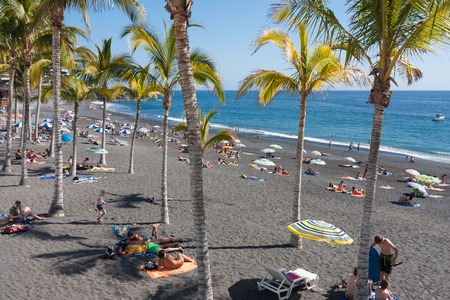 LA PALMA, SPAIN - JULY 30: Sunbathing people at beach with black lava sand on July 30, 2008 near Puerto Naos at La Palma Island, Spainのeditorial素材