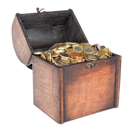 Wooden money chest filled with coins isolated at a white backgroundの写真素材