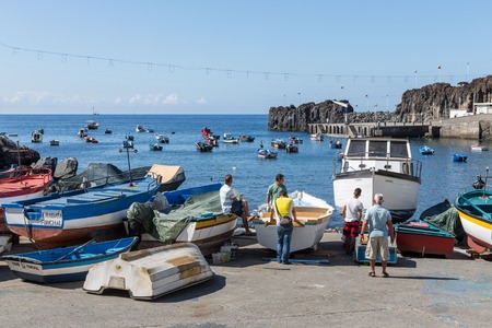 CAMARA DE LOBOS, PORTUGAL - AUG 04: Harbor with fishermen and fishing ships at the bay of Camara de Lobos on August 04, 2014 at Funchal, Portugalのeditorial素材