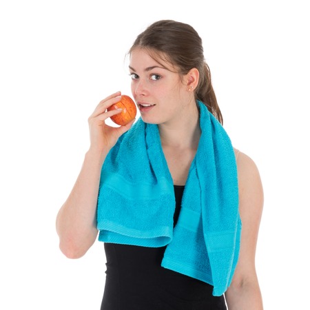 Cheerful fitness woman eating a red apple, isolated over whiteの写真素材