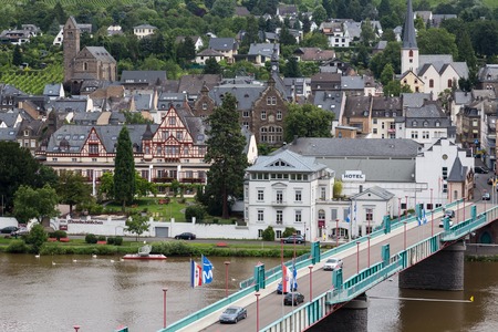 TRABEN-TRARBACH, GERMANY - JUL 16: Cityscape with people and cars crossing the bridge over river Moselle on July 16, 2012 at Traben-Trarbach, Germanyのeditorial素材