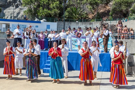 MADEIRA, PORTUGAL - AUG 10: Dancers with local costumes demonstrating a folk dance on August 10, 2014 at the beach of Funchal, Madeira Island, Portugalのeditorial素材