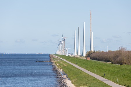Construction of a new windfarm along the Dutch coast with the old existing smaller windturbines still in productionの写真素材