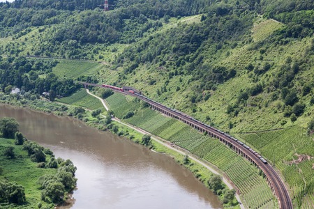 Aerial view of a passenger train and a freight train passing each other at a railway track along the river Moselle in Germanyの写真素材