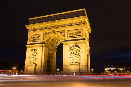 Evening view of Arc de Triomphe illuminated with light rails of passing traffic in Paris Franceの写真素材