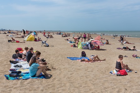 SCHEVENINGEN THE NETHERLANDS JUN 05: Seaside visitors relaxing at the first hot summerday on 5 June 2015 at the beach of Scheveningen the Netherlandsのeditorial素材