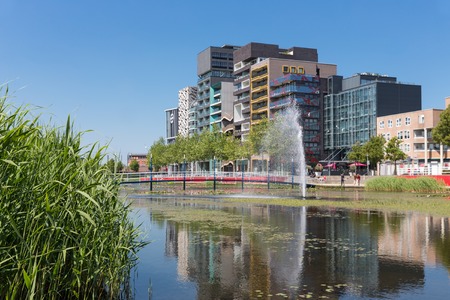 View at modern apartments and office buildings with pond and fountain in front of it Lelystad the...