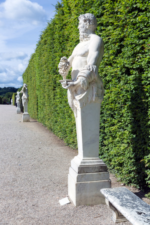 Footpath with ornamental statues in the garden of Palace Versailles near Paris, Franceのeditorial素材