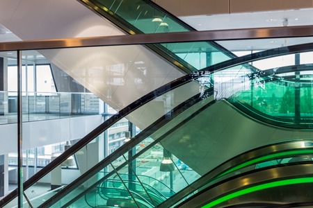 Escalators with green illumination in modern office building