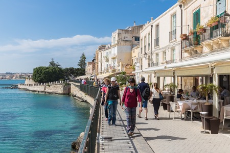 SIRACUSA ITALY - MAY 18: Tourists and restaurants near the harbor of Syracusa on May 18, 2016 at the island Sicily, Italyのeditorial素材