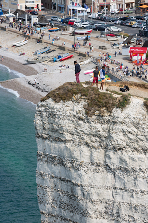ETRETAT, FRANCE - AUGUST 25, 2017: Aerial view of tourists standing at a high cliff near the beach and promenade of Etretat in Normandy, Franceのeditorial素材