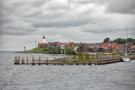 Seascape Dutch fishing village Urk with wooden jetty at entrance of harborの写真素材