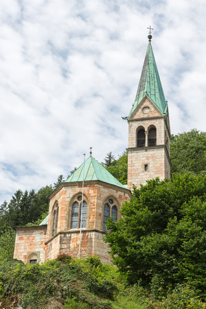 silhouette of church with tower against mountain slope with trees in Berchtesgaden, Germanyの写真素材