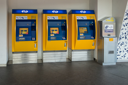 Delft, The Netherlands - march 15, 2018: Three yellow ticket machines at Dutch railway station of Delftのeditorial素材