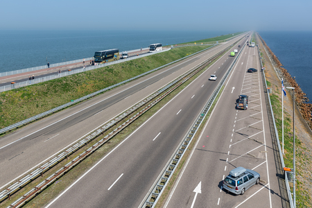Wieringen, The Netherlands - April 20, 2018: Dutch highway at the afsluitdijk. The dike is the connection between Friesland and Noord-Holland and separates the Waddensea from the IJsselmeerのeditorial素材