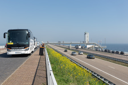 Wieringen, The Netherlands - April 20, 2018: International tourists arriving in buses to visit the monument at the location where the afsluitdijk is closed.のeditorial素材