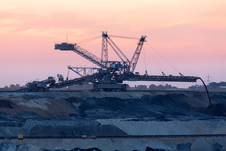 Sunset landscape brown coal open pit with digging machine in Hambach mine Germany