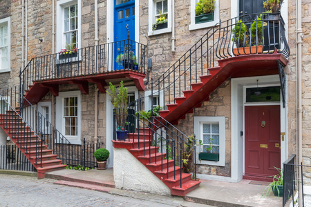 Facade of residential homes with two floors and a staircase in front of the houseの写真素材