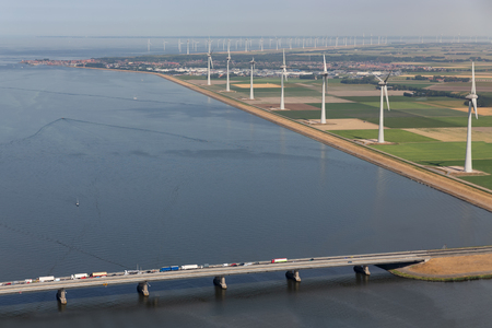 Aerial view Dutch landscape with bridge and turbines along the coast