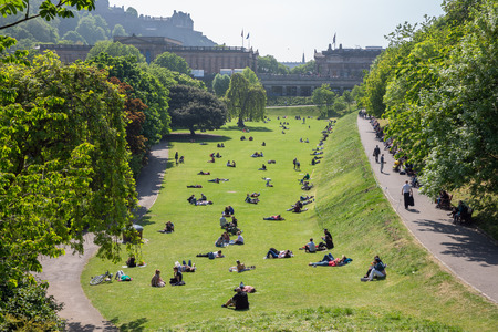 Edinburgh, Scotland - May 24, 2018: Princes Street Gardens with recreating people sitting and lying in the grassのeditorial素材