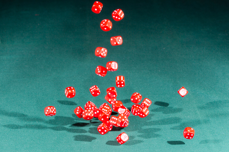 Thirty red dices falling on a isolated green table