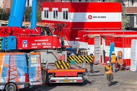 Lelystad, The Netherlands - April 5, 2019: Construction site with mobile crane, storage containers and crew wagonsのeditorial素材