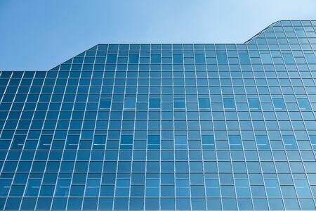 Glass facade modern office building with blue sky in Dutch city Utrechtの写真素材