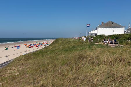 Domburg, The Netherlands - June 28, 2019: Hotel and pension near coast with seaside visitors relaxing at the beachのeditorial素材