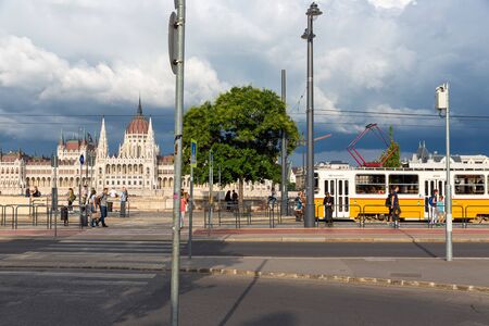 Budapest, Hungary - Juli 13, 2019: Tram stop Budapest public transport along Danube and opposite Hungarian Parliament Buildingのeditorial素材
