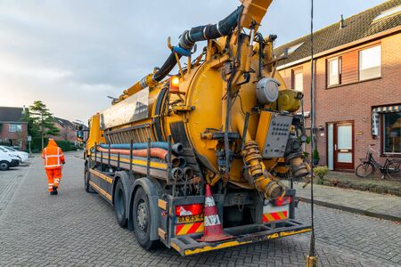 Urk, The Netherlands - September 07, 2019: Workers with specialized truck cleaning sewer system in residential areaのeditorial素材