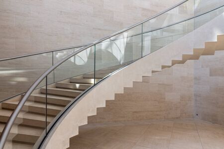 Modern curved staircase made form marble, steel and glass in colors grey and brownの写真素材