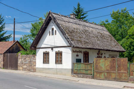 Szomolya , Hungary - July 07, 2019: Tiny house with white walls and reed roof in Szomolya, Hungaryのeditorial素材