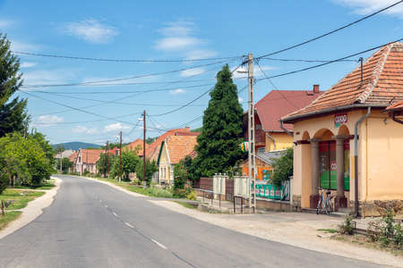 Szomolya , Hungary - July 07, 2019: Main street Hungarian rural village Szomolya with tiny supermarketのeditorial素材