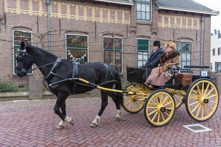 Urk, The Netherlands- February 13, 2010: Man and woman at horse-drawn carriage during festival in...
