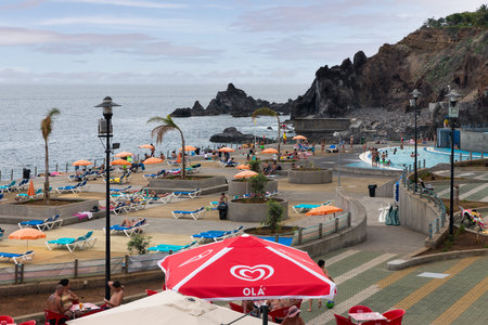 Funchal at Madeira, Portugal - July 31, 2014: Swimming pool with relaxing people at Atlantic coast of Madeiraのeditorial素材