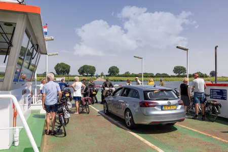 Ferry with cars, bicycles and pedestrians near Dutch village Cuijkのeditorial素材