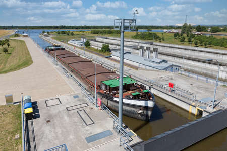 German sluice near Magdeburg with cargo ship in lock chamberの写真素材