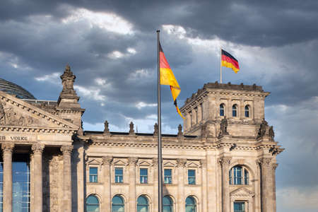 Facade Reichstag building Berlin with german flag and threatening airのeditorial素材