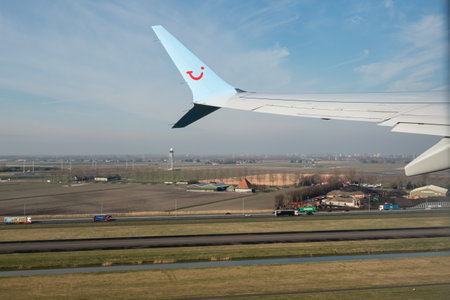 Wing airplane and Dutch countryfield juist after takeoff Schiphol airportのeditorial素材