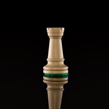Wooden white chess rook isolated at dark backgroundの写真素材