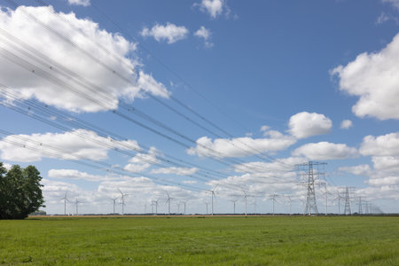 Dutch countryside in Groningen with windturbines and power pylons