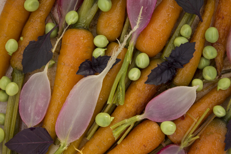 fresh roasted carrots, radishes and green peasの写真素材