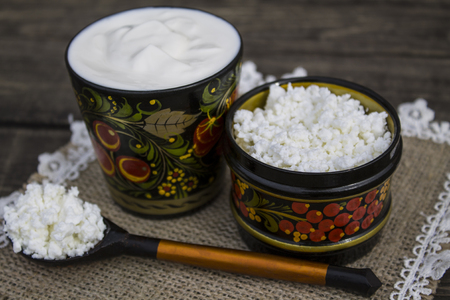 The cheese and sour cream in a bowl with Khokhloma paintingの写真素材