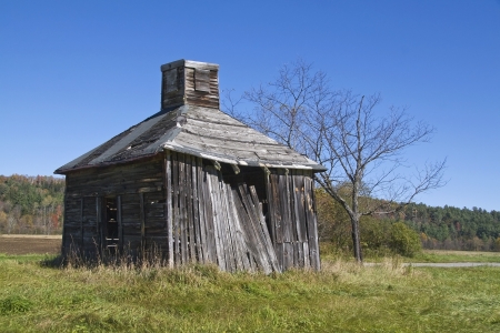 An old, square, wooden smokehouse in a field in the White Mountains of New Hampshire.の写真素材