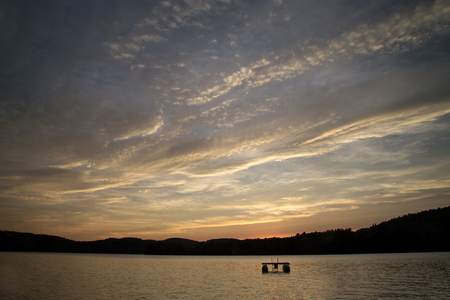Interesting sunset with clouds over Squam Lake, New Hampshireの写真素材