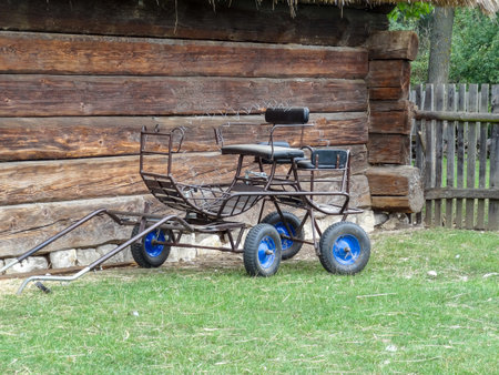 Old carriage on the background of an old wooden houseのeditorial素材