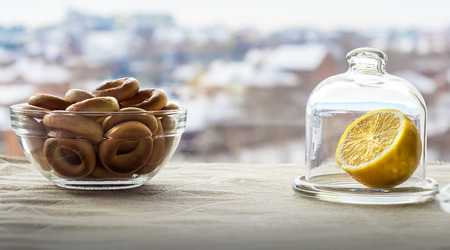 Snack with tea. Drying in a saucer and a lemon in a glass flask on the table.